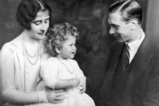 Pictured in 1930, the fouryear-old Elizabeth plays with her parents the Duke and Duchess of York.